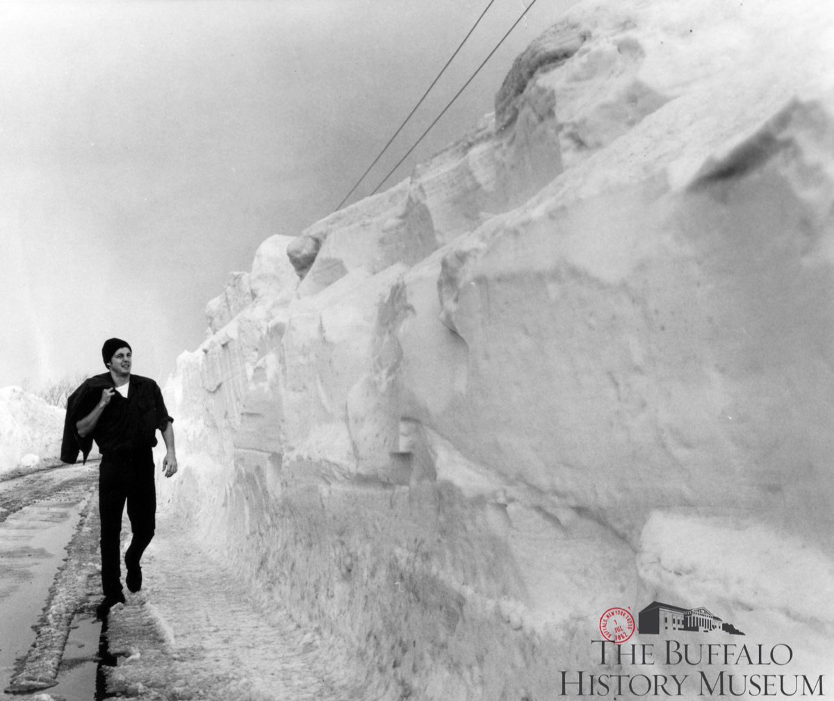 This weather has us reflecting on some snowy photos from our collection. One such photo is pictured here - an unidentified pedestrian with a quite literally a wall of snow after the Blizzard of 1977! #BuffaloHistory