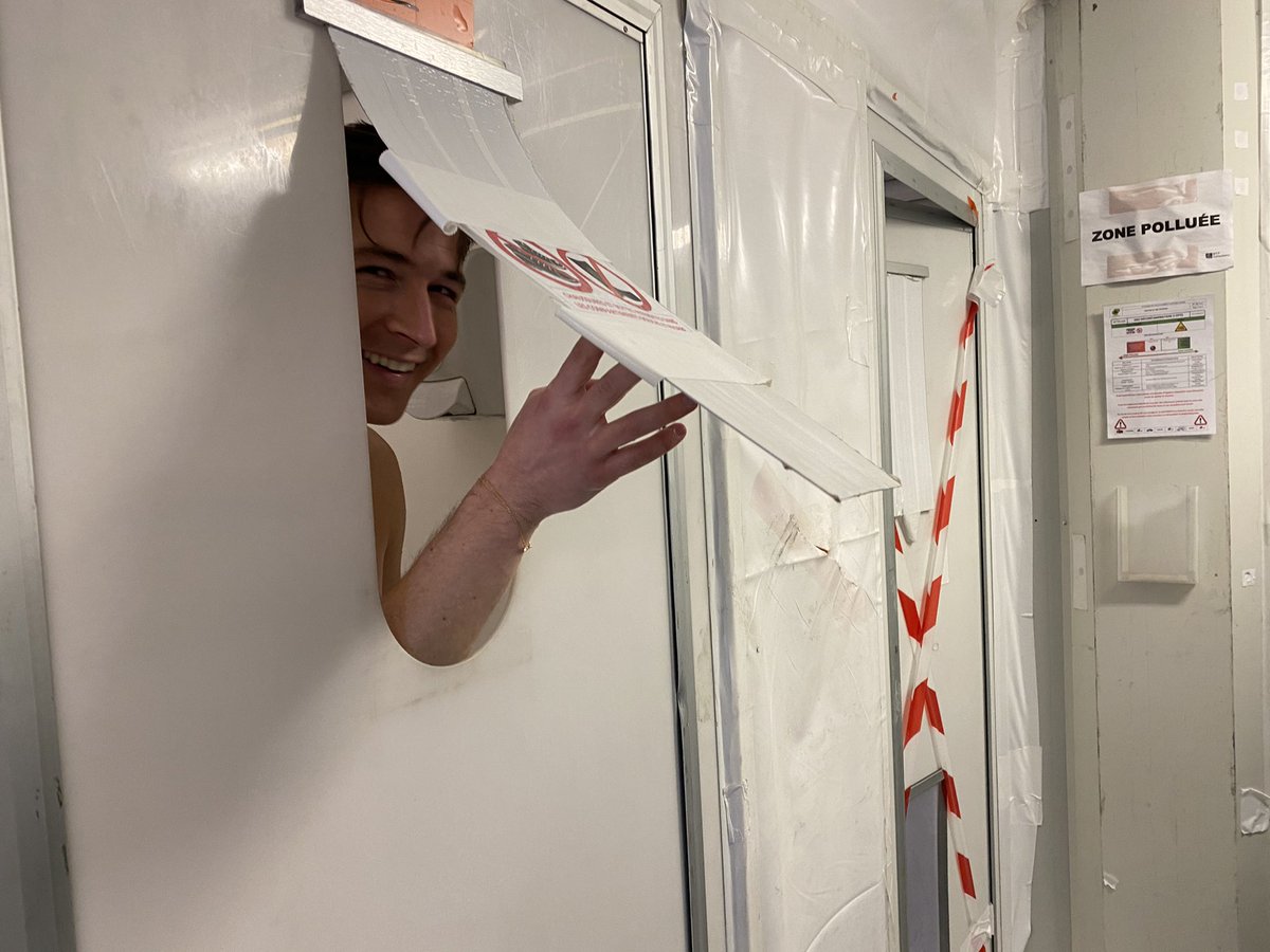 And then, at the end of an interesting and exciting day, our cameraman grabbed this photo of me asking for my phone (which I had to scrub) from the little flap in the decontamination shower