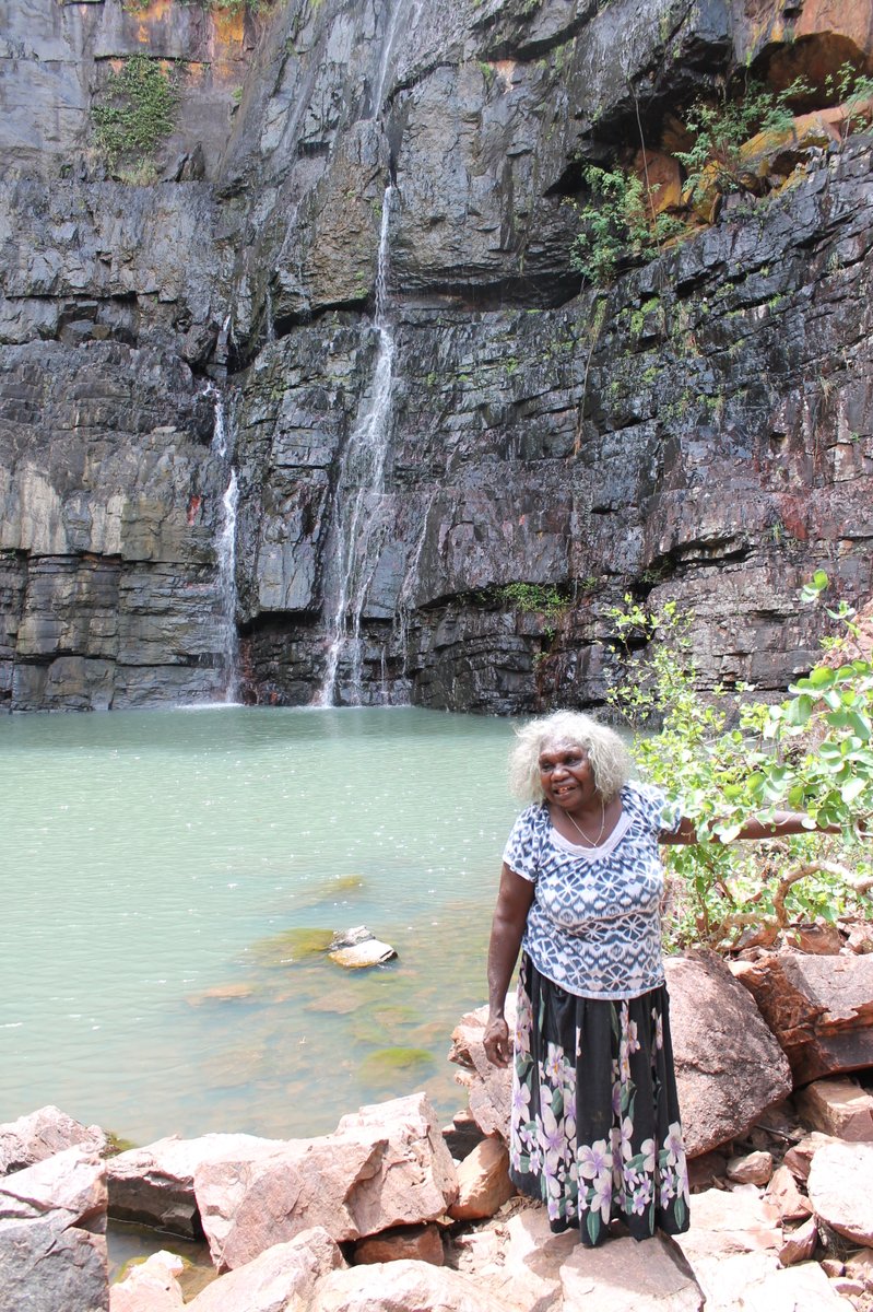The Miriwoong Word of the Week is Thegooyeng. In English, this place is called 'Black Rock'. Yamboong bare nyinanyan Thegooyem woolangem thoolooloorrng. Agnes is standing at Black Rock in front of the waterfall.