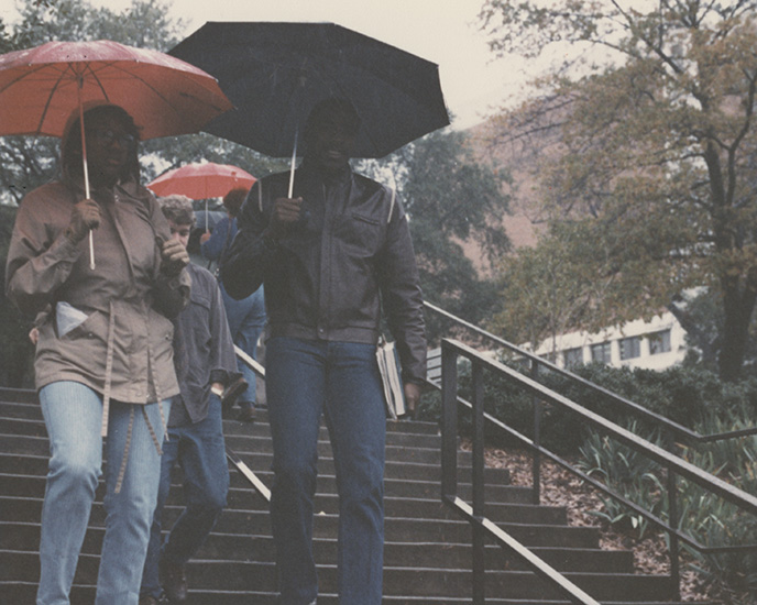 hargrettlibrary's tweet photo. Students walking to class on the @universityofga campus in the rain, circa mid-1980s.

#UGA #TBT https://t.co/VqhtaJA0A3