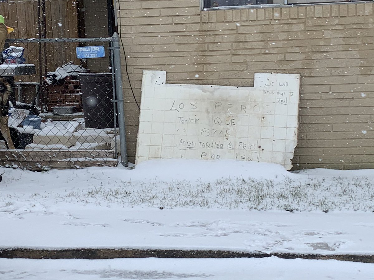 KatReportsTX's tweet photo. Neighbor delivering dog food to two pups left outside. Sign says in Spanish that it’s too cold for dogs. In English, “we will send you to jail.” https://t.co/TXF3QYaNLR