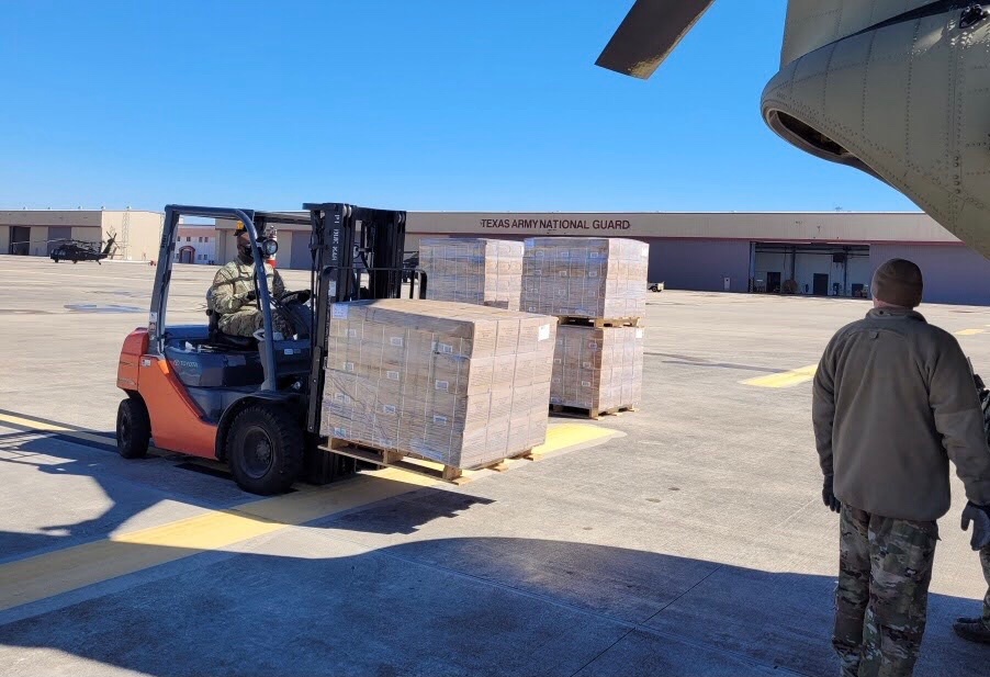 TXMilitary's tweet photo. Texas Soldiers load a Chinook helicopter with cases of food to be delivered to Texans in need. #TexansHelpingTexans https://t.co/CcwwCbg2uq