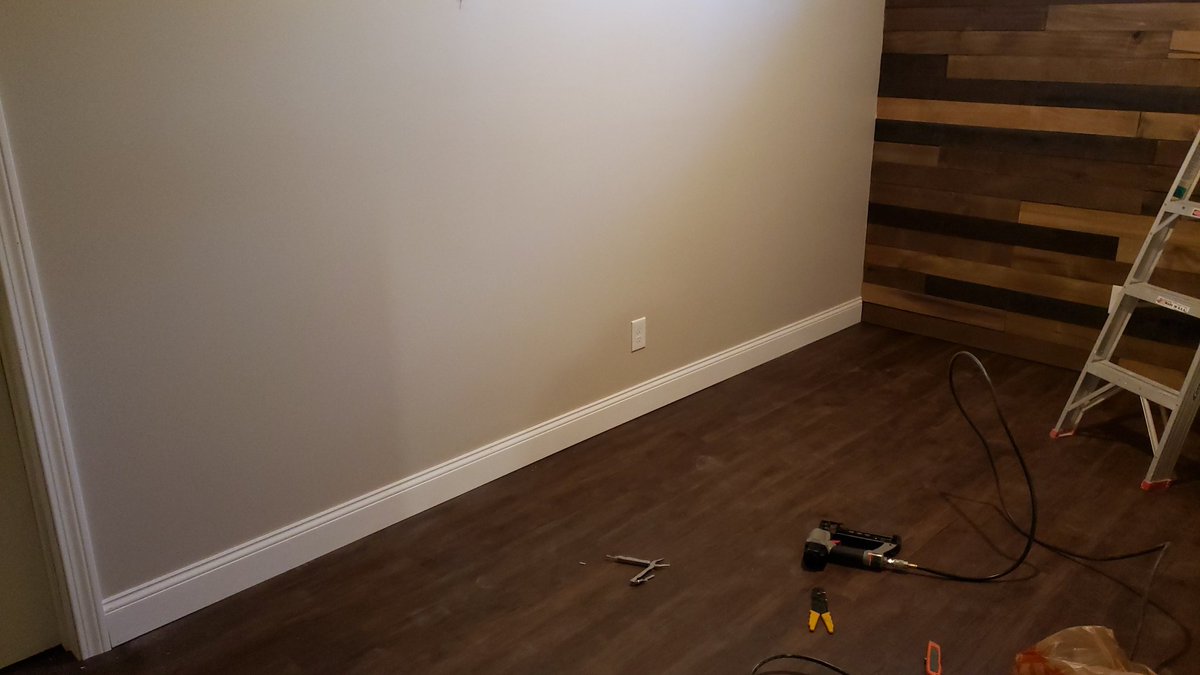 No baseboard on the wood wall...I think it looks better that way.