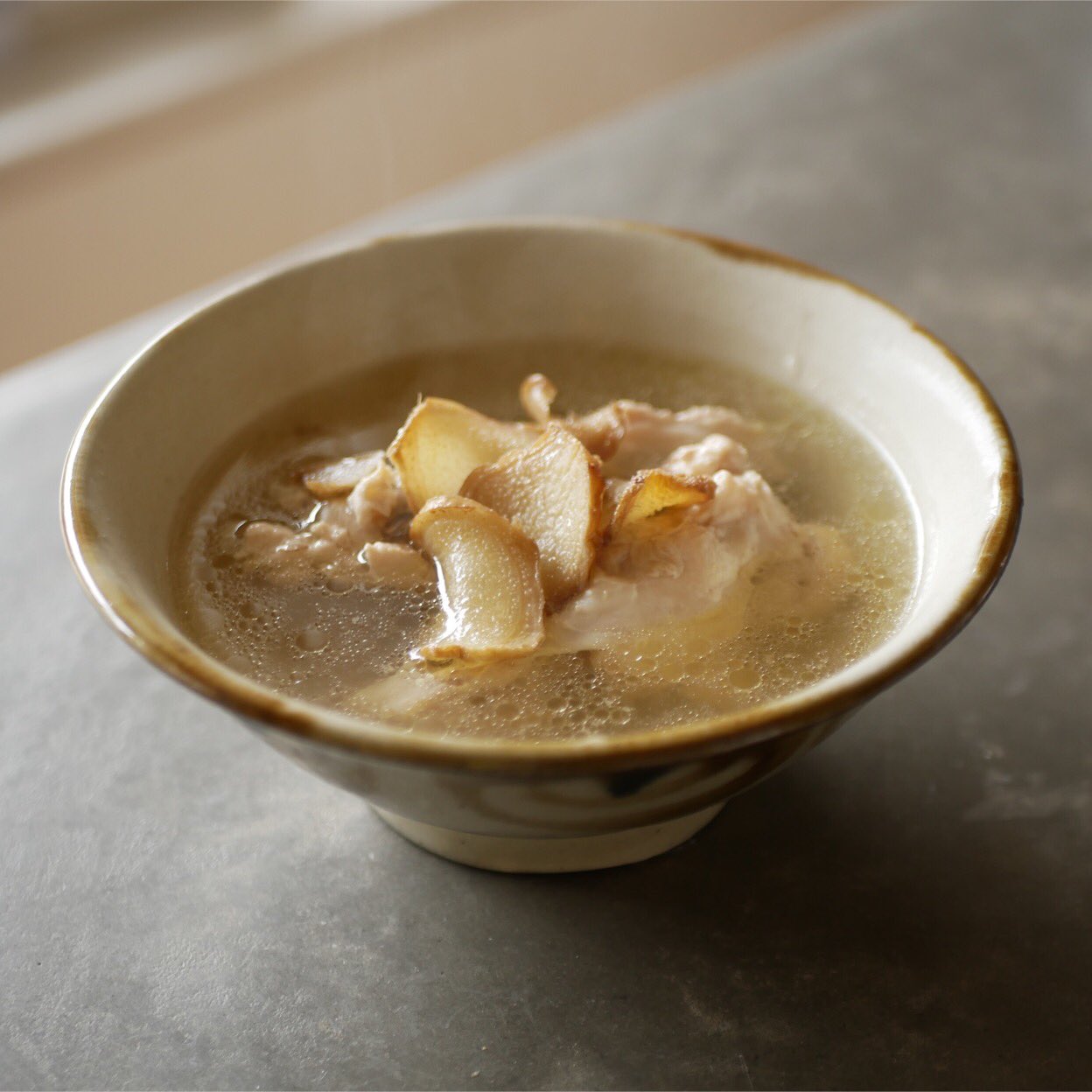 有賀 薫 麻油鶏 まーよーじー 台湾の 鶏 生姜 油だけで作るスープです 塩もだしも使いません 生姜の薄切りをこんがり炒めて 手羽元も入れ 水をたっぷりと注いで煮て 肉が煮えればokです 今朝は電鍋で作りました 焦がした生姜の香りがぶわっと