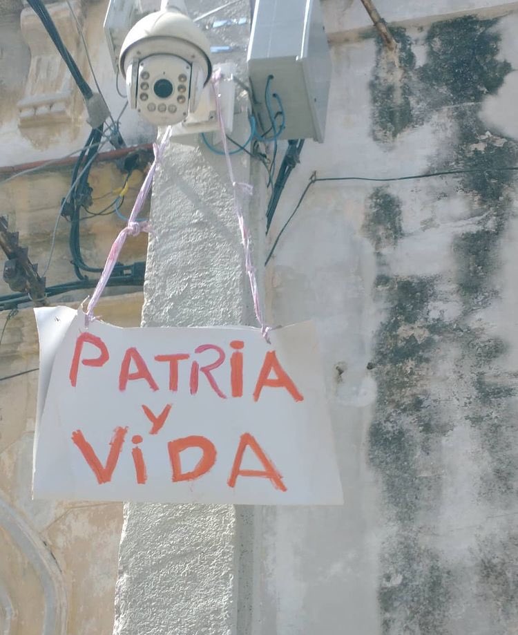 ngotranslations's tweet photo. #Cuba A nice looking #PatriayVida (#HomelandAndLife) sign hanging from the same camera used to surveil the home of dissident #artist @LMOAlcantara. 
Even UB 694 has joined the Patria y Vida Movement for FREEDOM.
#Canada #HumanRights @AtRiskArtists  @Freemuse98 @CADAL @charanzova https://t.co/Ez3J75oTrj