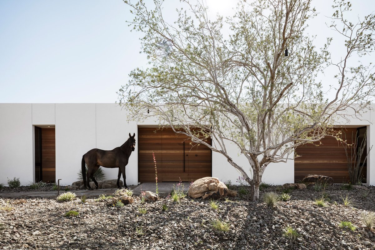 White stucco walls, solar panels, and a hidden courtyard feature in this dreamy desert home in Arizona by The Ranch Mine. See more: dezeen.com/2021/02/24/the…
