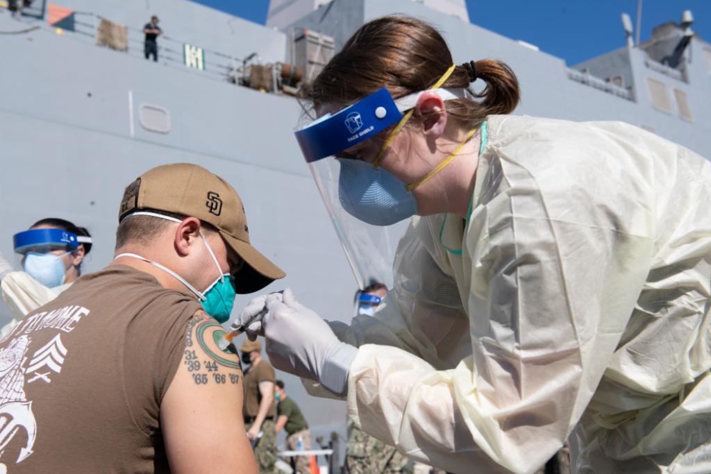 USNavy's tweet photo. Protecting the fleet; Protecting each other #SinkCOVID 💉 ⚓ 

#USNavy Medicine Readiness &amp; Training Unit Bahrain administers the COVID-19 vaccine to personnel from the amphibious transport dock ship USS San Diego (LPD 22) in Manama, Bahrain, Feb 26.  @US5thFleet #NavyReadiness https://t.co/0fd7Sxct8b