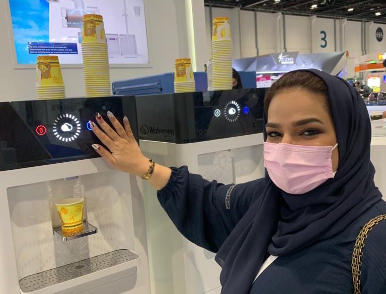 مواطنة اماراتية تتصور جنب الابتكار الاسرائيلي الذي طورته شركة “ووتر جين” جهاز توليد المياه من الهواء، أو ما يسمى ب”جينيو…