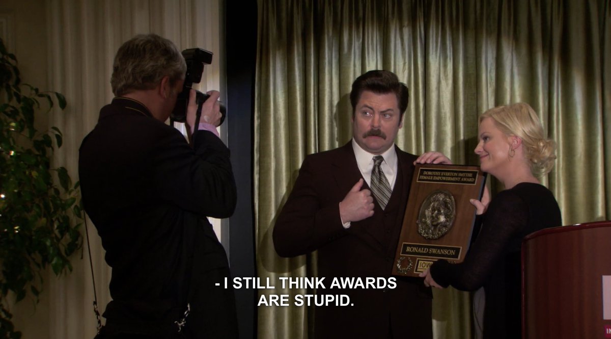 Screenshots from Parks and Recreation. Ron Swanson (Nick Offerman) and Leslie Knope (Amy Poehler). Text: I still think awards are stupid. 