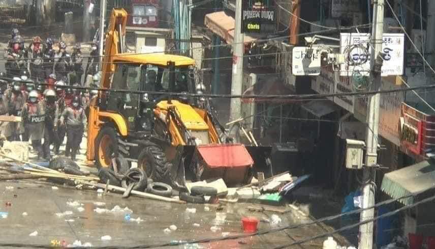 PorcelainJb's tweet photo. Protestors and citizens in Sanchaung , Yangon are under attack by security forces. Some protestors got arrested brutally. The barricades are damaged severely by bulldozers. Even peaceful citizens living nearby are dragged out of their apartments #WhatsHappeningInMyanmar #Mar1Coup https://t.co/paGCZCrT2K