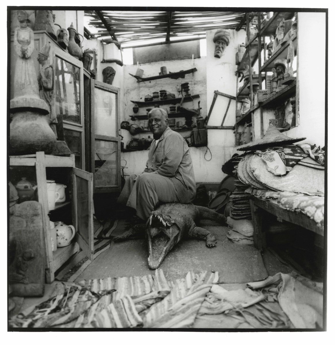 Portrait of a man in his store. Nubian Village, Aswan, Egypt, December 2020 The shop was full of taxidermy, so I asked if the owner if he would pose with his favourite piece. He sat on the Crocodile for the picture. Shot on @Hasselblad 503 on @Kodak #trix400 and hand-printed.