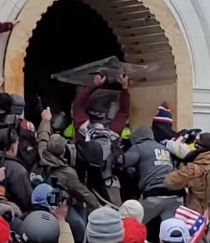 MalagaBridget's tweet photo. @SeditionHunters In this video, #CranOceanSprayer hits police with shield repeatedly and throws it at them. He then moves away from tunnel, turns his hat around and puts on goggles. See him moving toward police with shield beginning 0:32 https://t.co/99ROd8hBZ0 https://t.co/WXF9sYvb9C