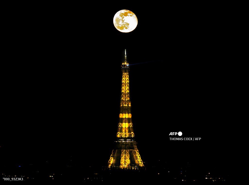 AFPphoto's tweet photo. The waning gibbous moon appears in the sky following the weekend's full "Snow Moon", near the Eiffel Tower in Paris, France. #AFP 
📸 @TomCOEX https://t.co/z2ovSTXfM3