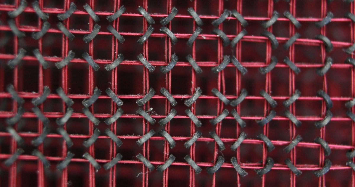 A closeup of the core plane shows black ferrite rings in a matrix with red wires threaded horizontally and vertically through them. The rings are at an angle, sloping left and right alternately.