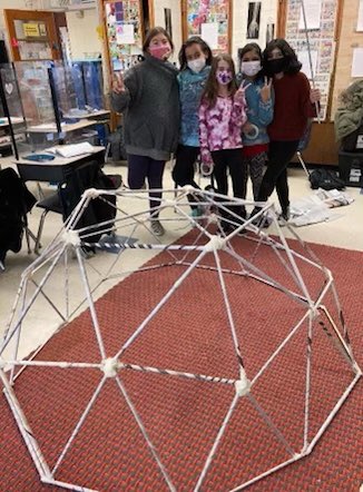 FYI - Mr. La Ruina's 5th grade math class at GM built a geodisc dome. Using recycled newspaper and masking tape, they rolled the newspaper into struts. Struts were measured in two sizes and then put together using masking tape. Students applied a variety of math skills.