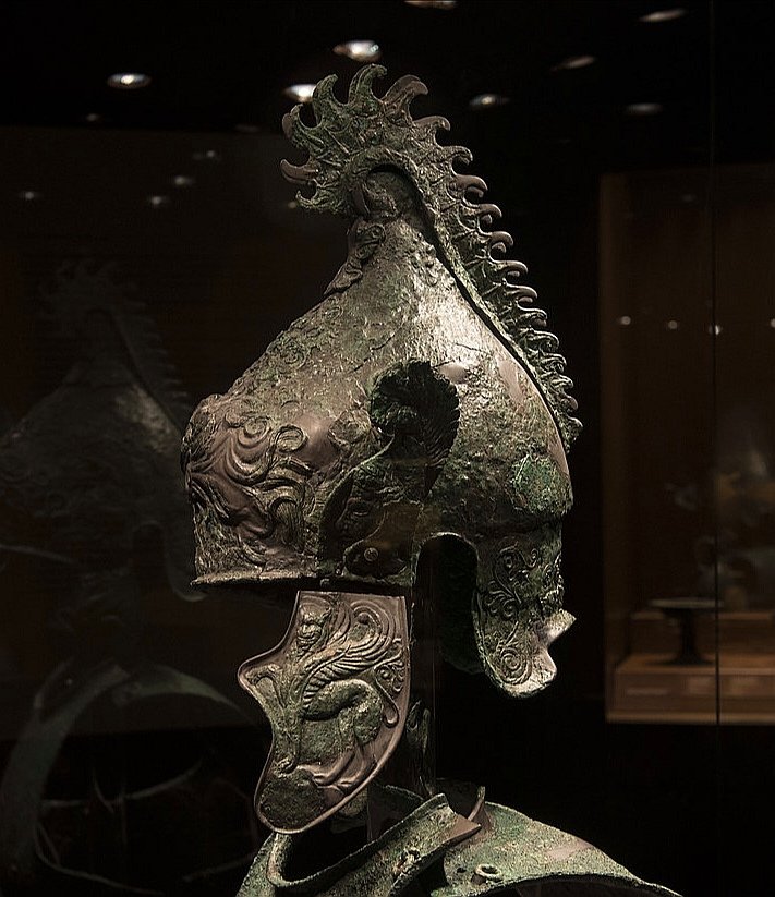 A 4thC BC bronze Etruscan Phrygian type helmet with a brilliant "chainsaw" styled crest found in Cortona, Italy. The helmet has beautifully embossed decorations and wings attached to the sides, it would have been quite a sight when originally highly polished.