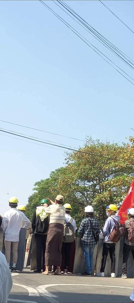 Fullmoonyu23's tweet photo. A man, who is seem to be the father, supporting the hat and mask to the son who is protecting the front line.

#အရေးတော်ပုံအောင်ရမည်
#MilitaryCoupInMyanmar
#WhatsHappeningInMyanmar
#Mar5Coup

Photo - Sterling
Source - https://t.co/EHLkLq3qMv https://t.co/QoIuflxU1w