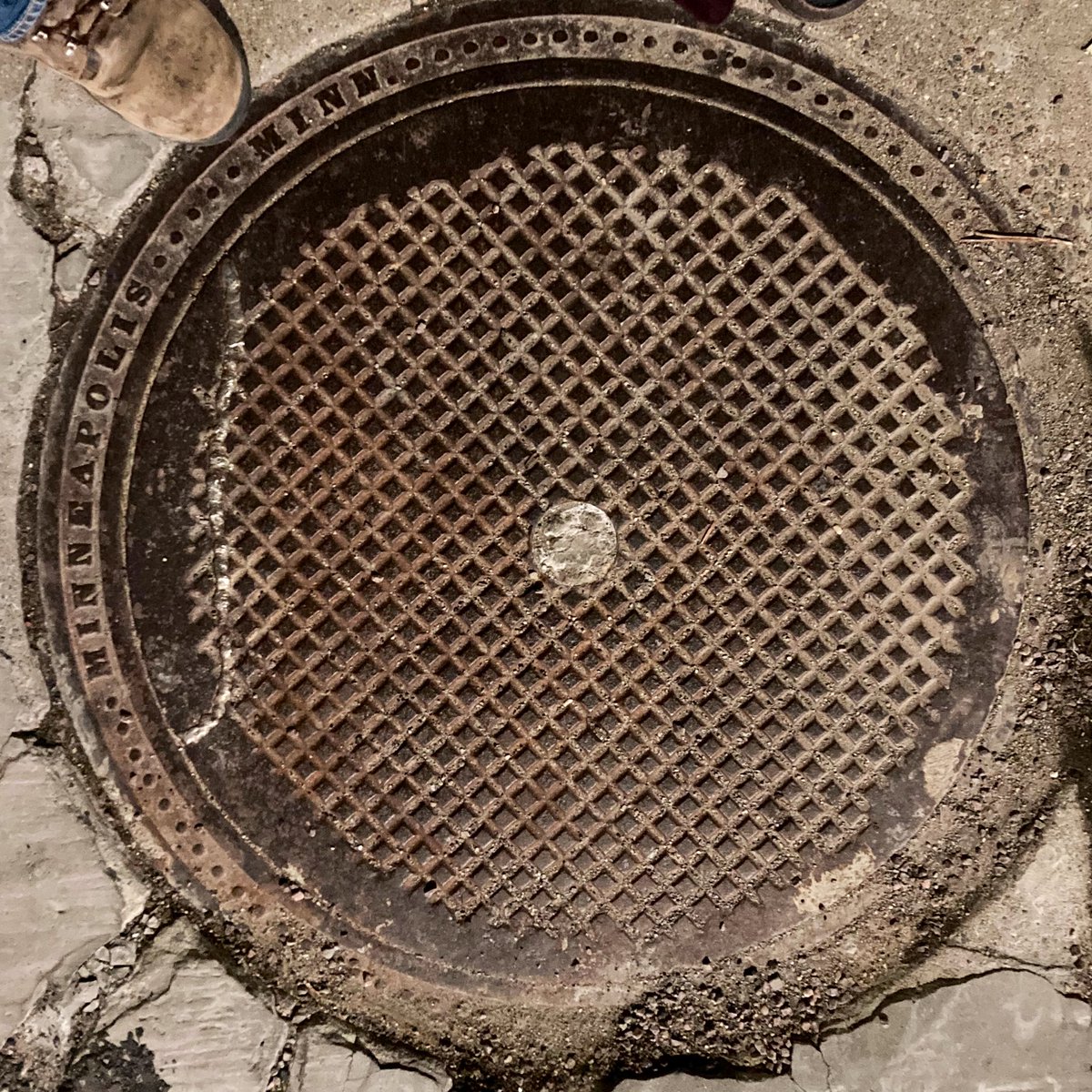 A weld on an old sewer lid. Used to be partly covered with sidewalk concrete, and the theory is that in hammering the concrete off, they damaged the lid as well, necessitating the repair.