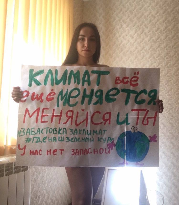 An FFF Russia activist holding a sign "Климат все ещё меняется, меняйся и ты. У нас нет запасной планеты", translated: "The climate continues to change, time for you to change too! We don't have a Planet B"