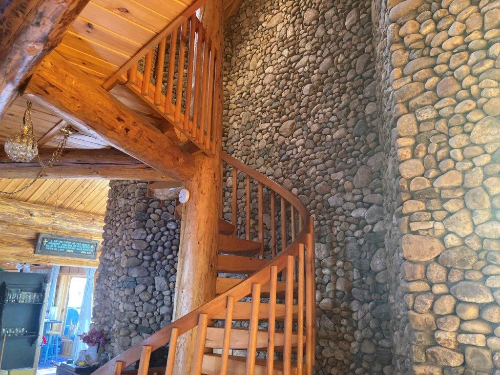 One of our more elaborate fireplaces and staircase from a log home completed over thirty years ago. #logcabin #loghome #customlogbuilder