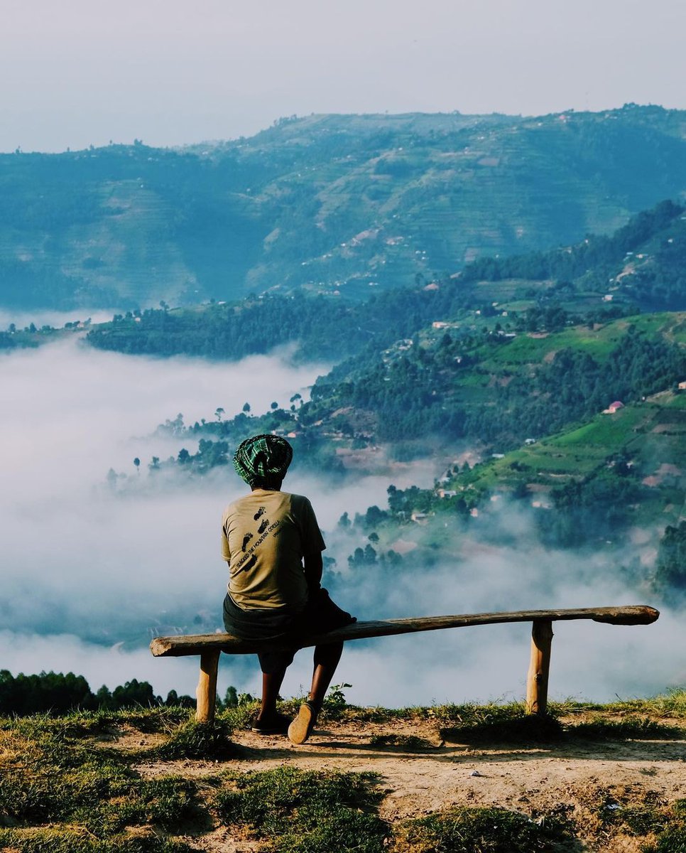 A woman overlooks the misty Kisoro highlands. Photo by <a href="/joostbastmeijer/">Joost Bastmeijer</a>