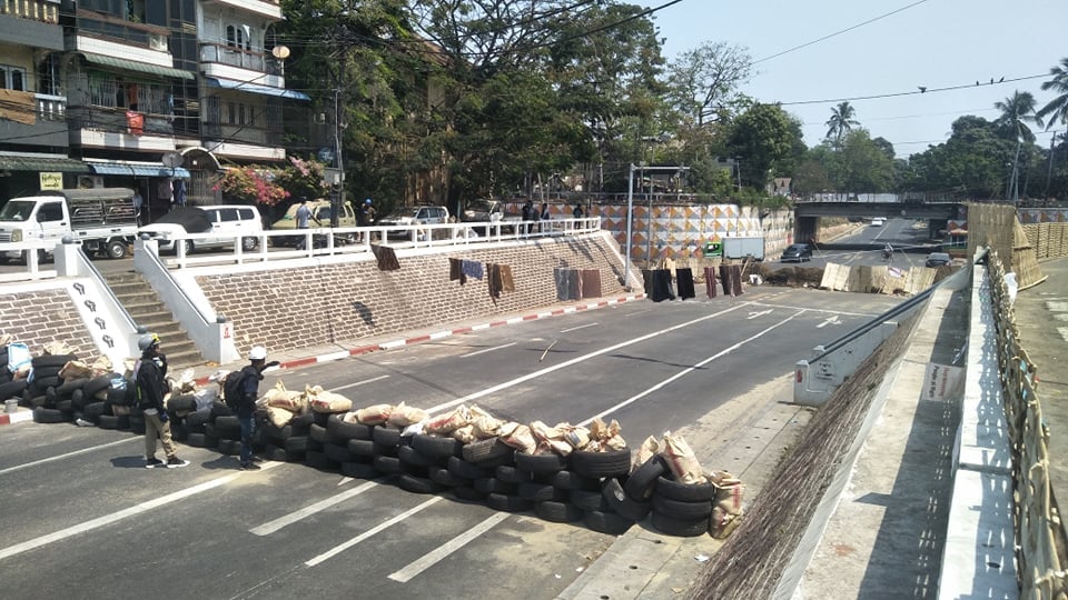 IrrawaddyNews's tweet photo. Hundreds of anti-regime protesters gathered in #Yangon’s Kyimyindaing Township on Tuesday, despite riot police erecting blockades in the morning, following raids on Sanchaung Township during the previous night. 
#WhatIsHappeningInMyanmar 
#RejectMilitaryCoup https://t.co/CbQJtWxDgV