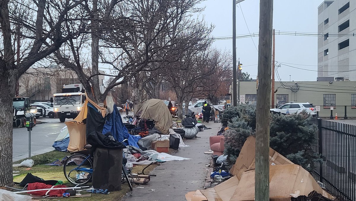userjame's tweet image. 25+ Denver Police officers have shut down 3 city blocks with fences downtown. The posting claims this is an "encumbrance removal" despite clear passage on all sidewalks. 

Dozens of residents are at risk of displacement and the destruction of their belongings.  
#denverprotests