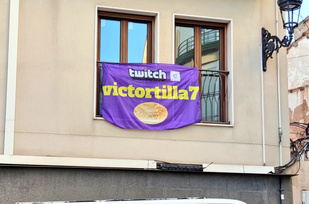 VicBoronat's tweet photo. He estado dándole vueltas a la forma de promocionar mi canal de twitch y lo mejor que se me ha ocurrido ha sido colgar una bandera en mi balcón con mi nombre y una tortilla gigante. https://t.co/CSJtQlRw5Z