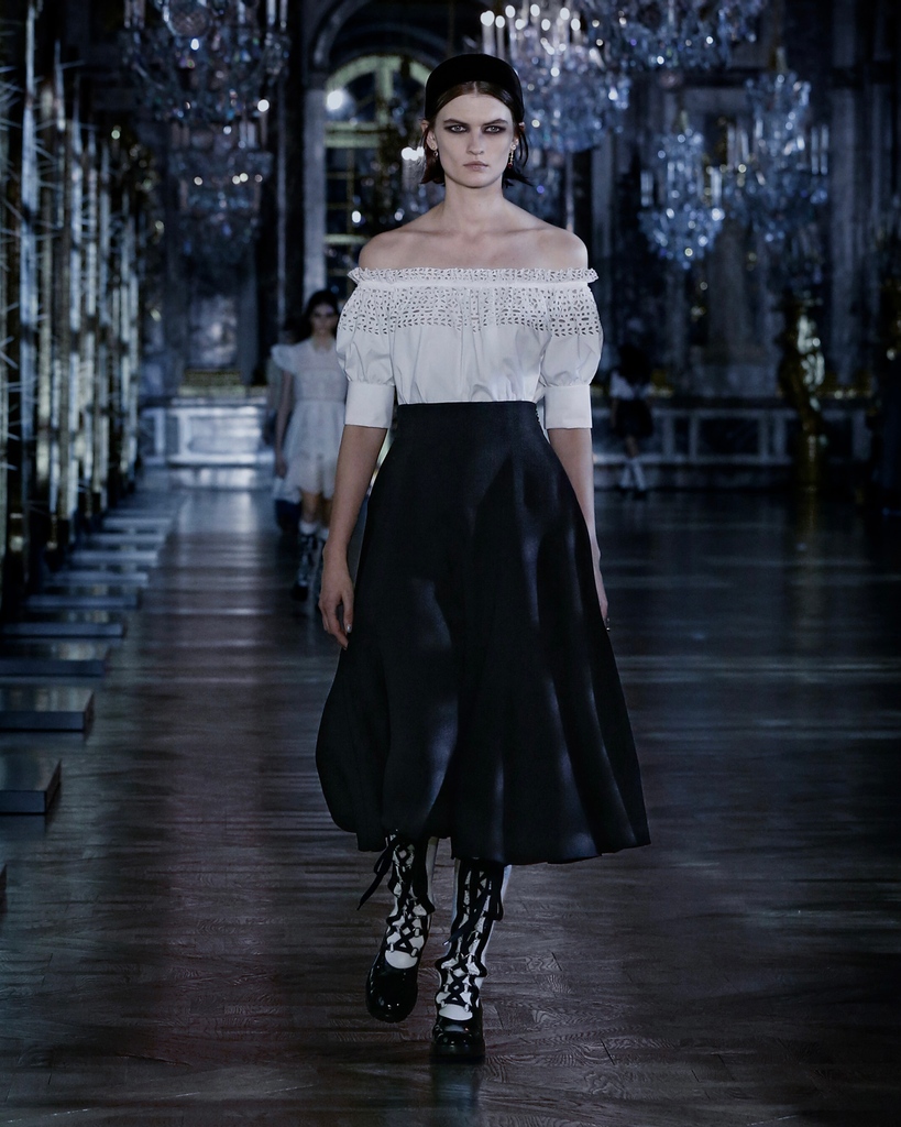 Dior's tweet photo. Walking the line between pure femininity and the sensuality pulsing through the old fairy tales that inspired #DiorAW21 https://t.co/C0sJH9mR97, Maria Grazia Chiuri turned to the delicate openwork of broderie anglaise for full-skirted dresses and body-baring separates. https://t.co/EBxlkEkRKS