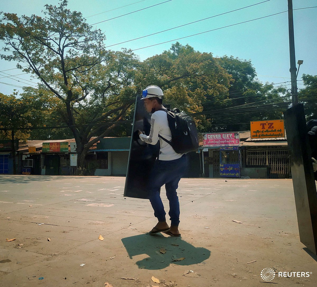 Chit Min Thu hides behind a shield during an anti-coup protest in North Dagon, Yangon, Myanmar March 11, 2021 in this still image obtained by Reuters.  #WhatsHappeningInMyanmar
