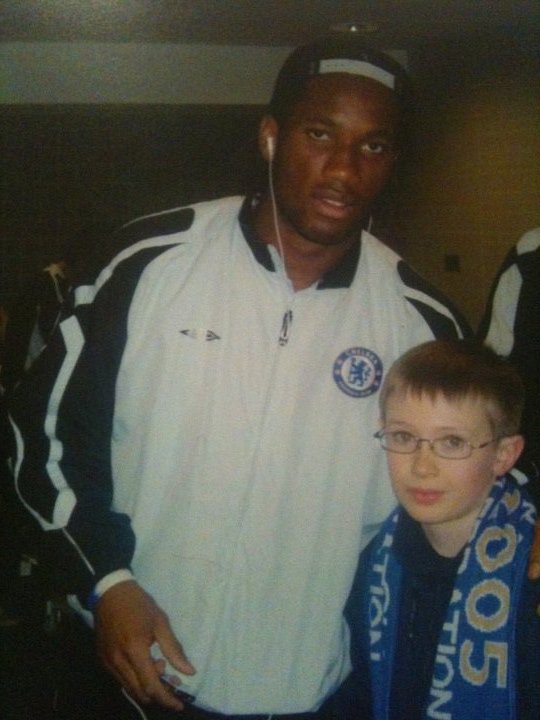 PatskiMcCann's tweet photo. @ChelseaFC @didierdrogba A pic of me with the King, just before our Champions League game vs Barcelona in 2005. Was the mascot for the game. Should have smiled more! 😅 https://t.co/BUeZjgpGkz