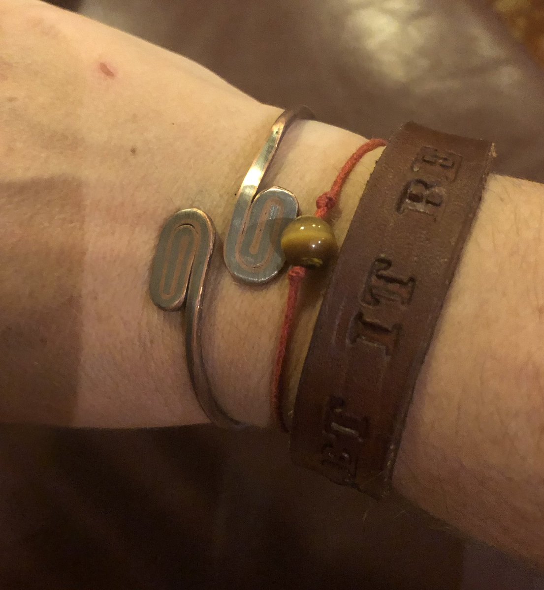 Lanalab's tweet photo. My bracelet collection is coming along nicely again. The red one is to remind me to be kind, even to myself. The metal one is made out of poachers’ snares 😔 the proceeds go to conservation of wild animals. #WearTheStory #DestructionIntoHope #BeKind #LetItBe https://t.co/VxYUGl63N1