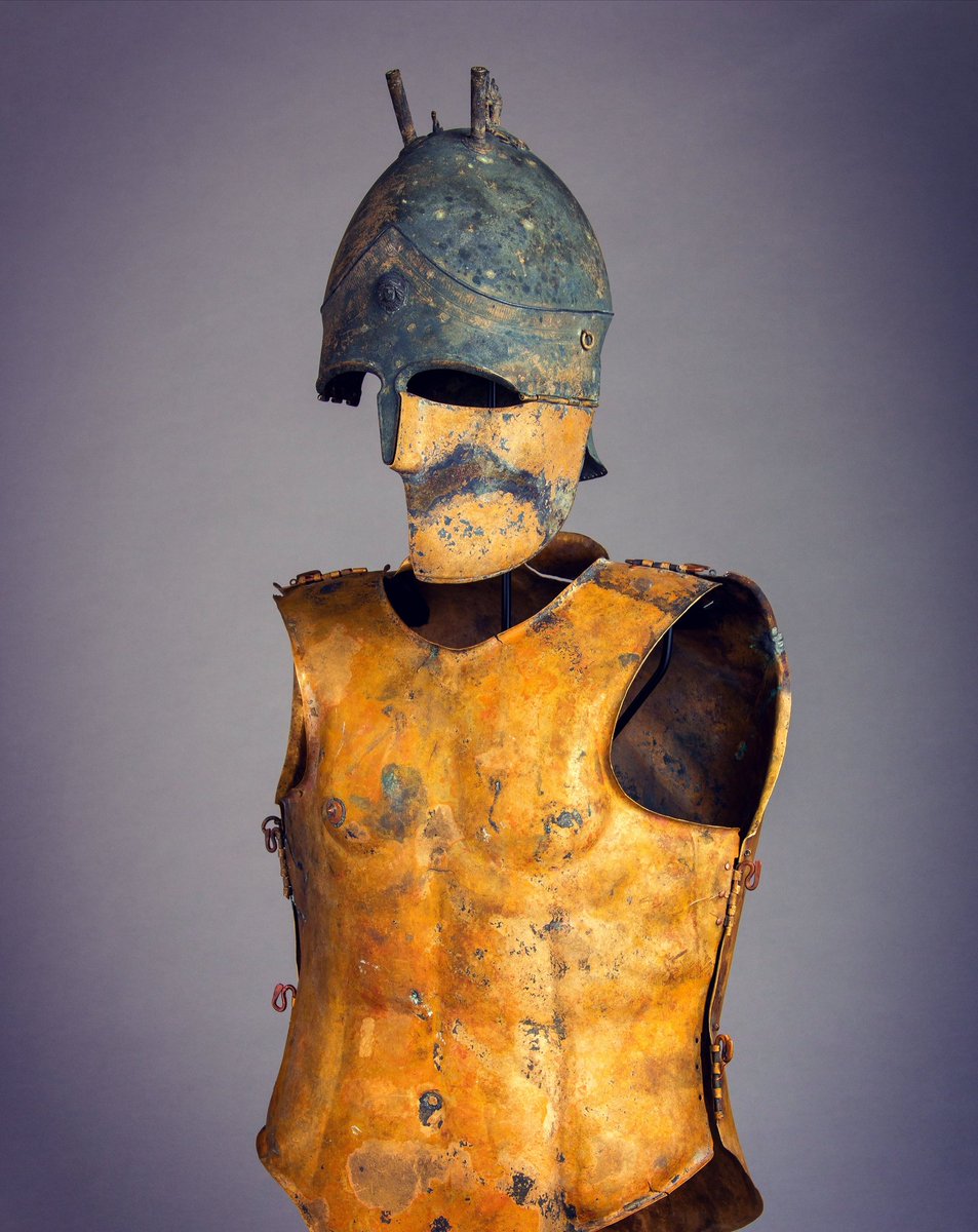 This 5/4thC BC Etruscan panoply is one of the finest examples to survive from the ancient world. The beautiful Italo-Chalcidian type helmet has unique hinged cheekpieces that enclosed the face and were made to closely follow the contours of the warrior's cheekbones and jawline.