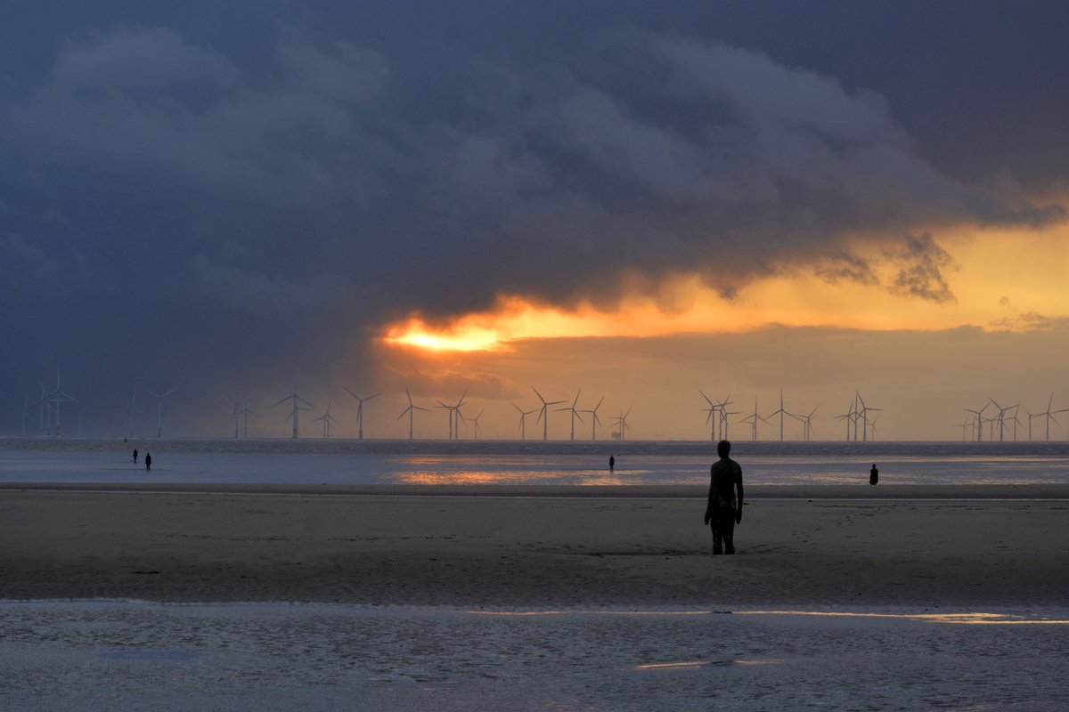 Yesterday evening squalls of rain chased across Liverpool Bay, hiding the sun from viewers on Crosby beach. A sudden parting of the clouds and bright, golden orange light flooded the scene for an instant but was quickly extinguished again by the racing clouds. <a href="/IronMenCrosby/">IronMenCrosby 🌤</a>