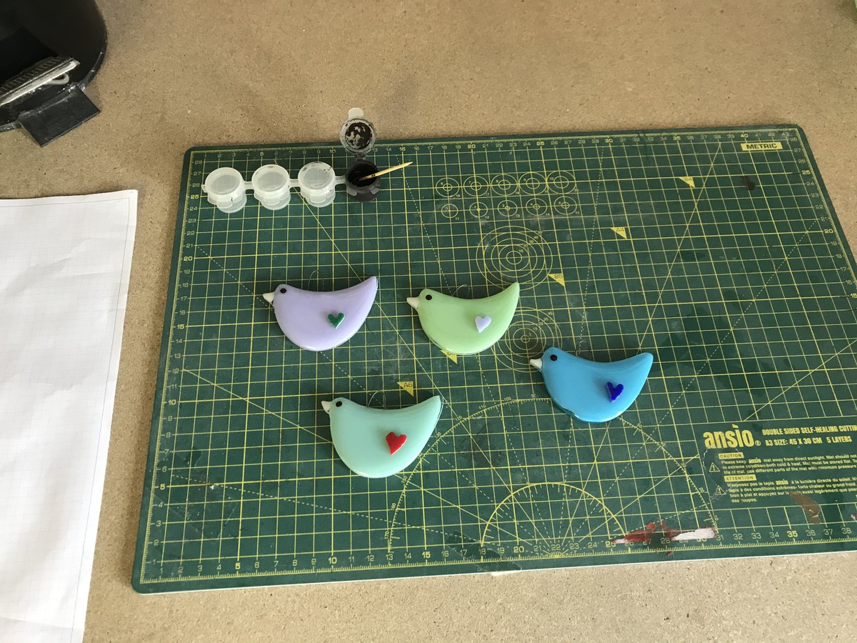 GlintLight's tweet photo. Spent Sunday morning Just finishing off this small flock of birds. I think my favourite one is the Robin egg blue with the red heart it has a very cute face. #fusedglass #folksy https://t.co/DNhXrmL4BX