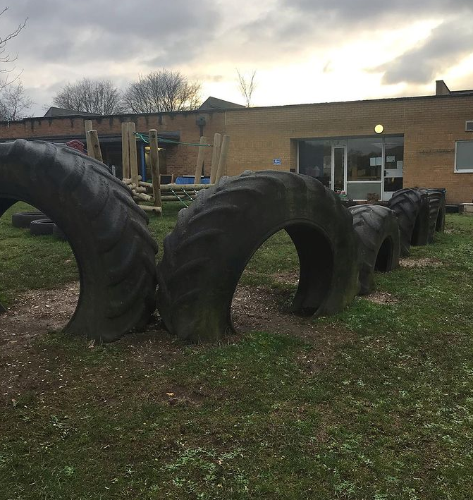 Tractor tyres partially buried make fun arches to scramble through!