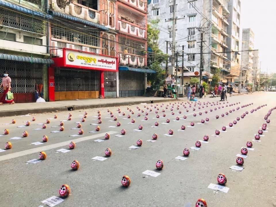 NaingOK2's tweet photo. Ahlone tsp, Yangon:Pyit Tai Htaung traditional toys are placed on street with placards to demonstrate. These toys symbolize resilience,perseverance and never give up, as literally each time it is thrown, it always stands upright after being knocked down. #WhatsHappeningInMyanmar https://t.co/NdehThromV