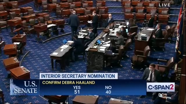 screenshot of senate floor that shows the senate and 4 people scattered throughout the room. the bottom shows the final senate vote reading "interior secretary nomination. Confirmation Debra Haaland. 51 Yes, 40 No. on C-SPAN2