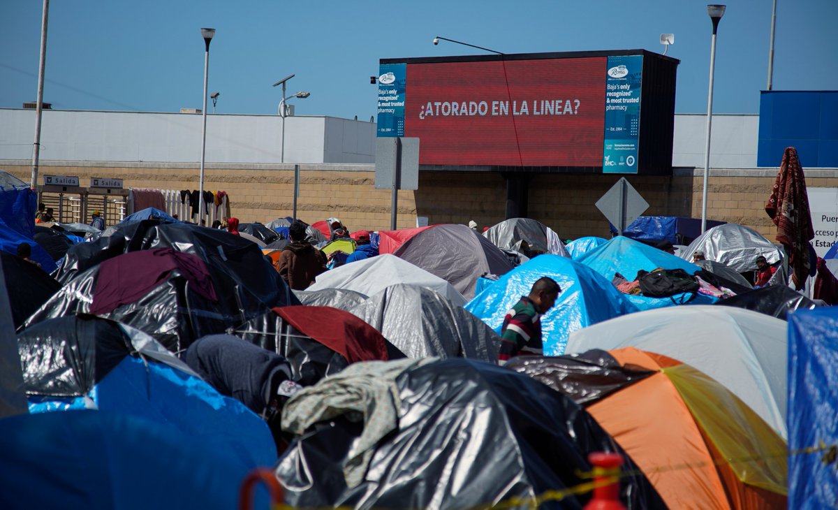 The billboard says it all (stuck at the border).  Asylum seekers camping out at Chaparral.