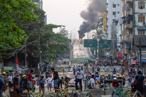 TostevinM's tweet photo. Anti-coup protesters walk behind a barricade as fire burns on Bayint Naung Bridge in Mayangone, Yangon, yesterday #WhatsHappeningInMyanmar @reuterspictures https://t.co/nxnVdE54QG
