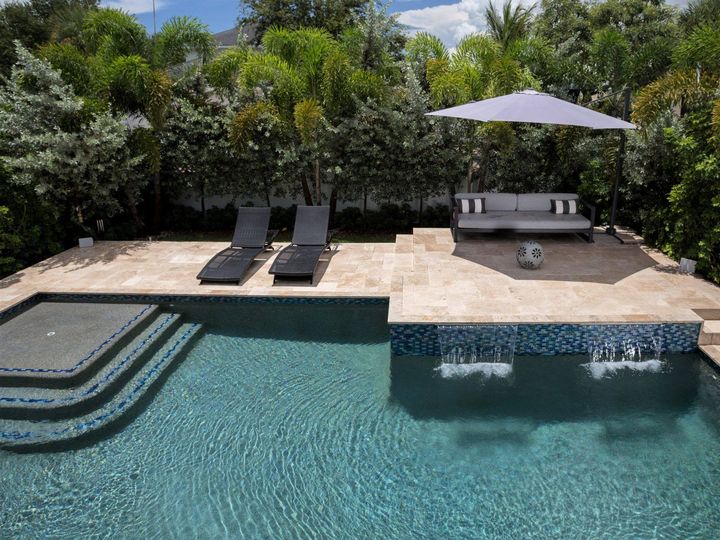 This backyard has all of the elements of a perfect outdoor living area: refreshing swimming pool, comfy seating with shade, burbling water f...