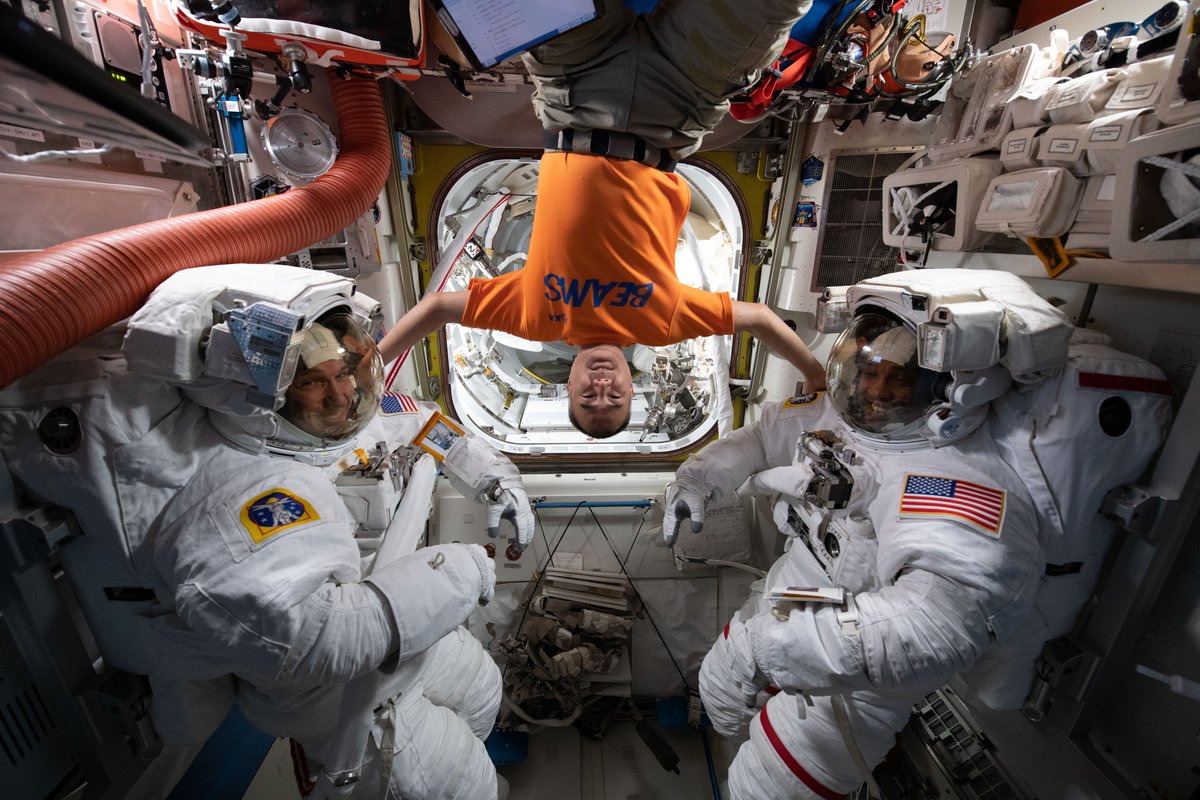iss064e042015 (March 13, 2021) --- JAXA (Japan Aerospace Exploration Agency) astronaut and Expedition 64 Flight Engineer Soichi Noguchi poses for a playful portrait with the suited up NASA spacewalkers (from left) Michael Hopkins and Victor Glover. The duo would go on to service the International Space Station’s cooling system and communications gear during a six-hour and 47-minute spacewalk.