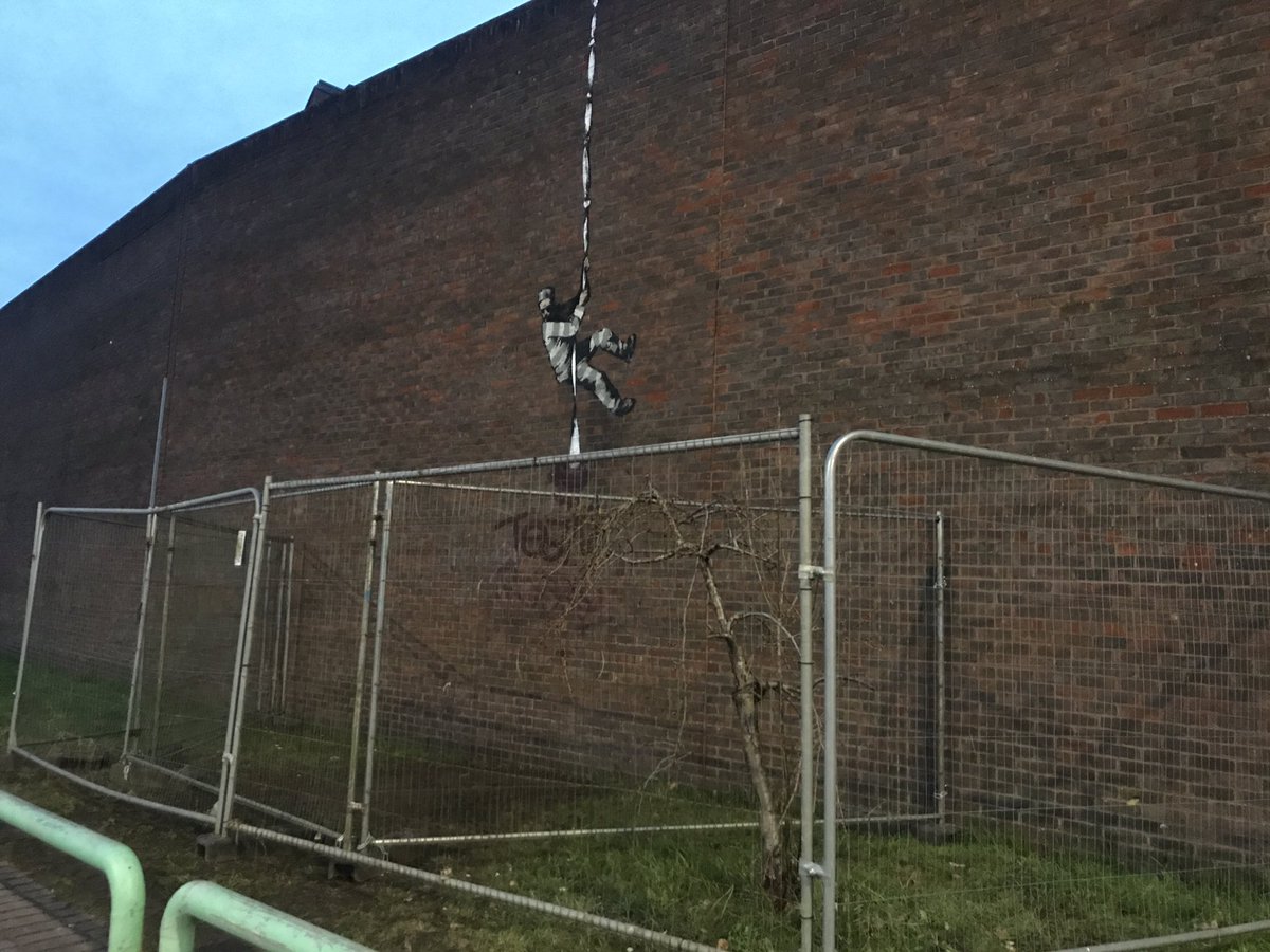 ChrisMasonC's tweet photo. More updates on the #Banksy on #ReadingPrison this morning. The @MoJGovUK have put up temporary metal fencing to protect the street art after it was defaced. Get the latest on this with @andrewpeach on @BBCBerkshire. https://t.co/FLwXhVxWNt