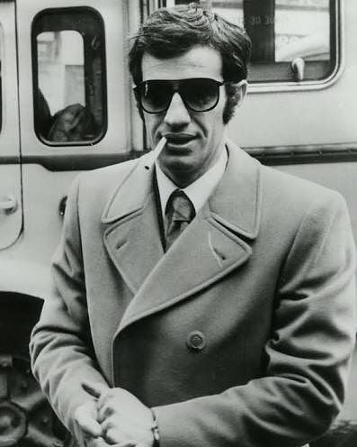 Jean-Paul Belmondo, wearing sunglasses and overcoat