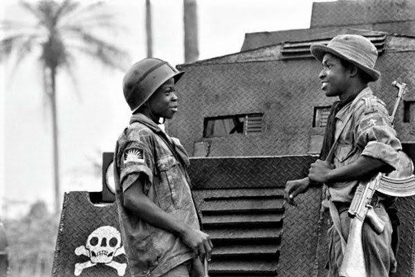 IgboHistoFacts's tweet photo. Two young soldiers of the Biafran army, Nonso, 14 (L) and Tochukwu, 16 (R) talk to one another in the city of Umuahia on August 31, 1968 as the Nigerian federal troops continue their advance during the Biafran war. #IgboHistory https://t.co/yqtdEzBE0B