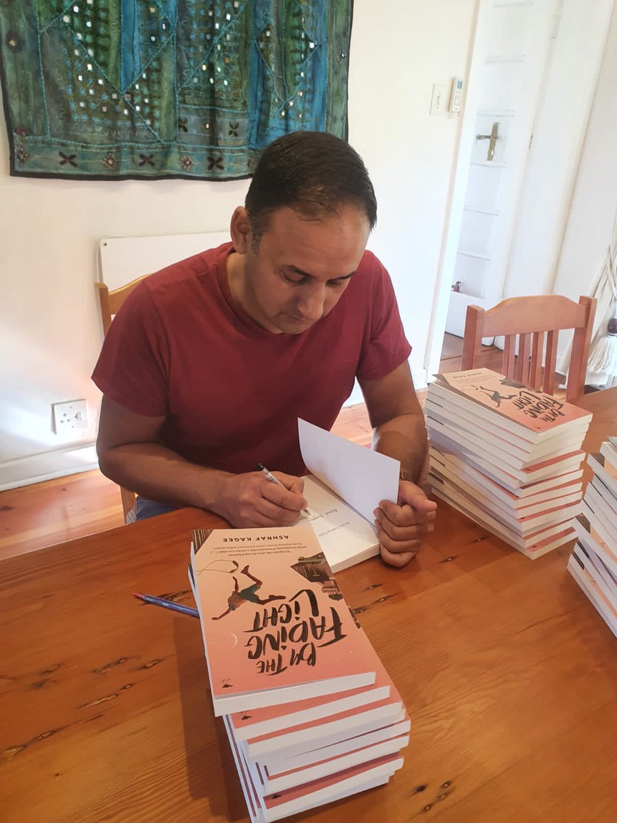 JacanaMedia's tweet photo. Hot off the press! Ashraf Kagee signing copies of his brand new novel #ByTheFadingLight! These copies will make their way to @readerwarehouse stores all over South Africa. https://t.co/3YKQ9P8RF5