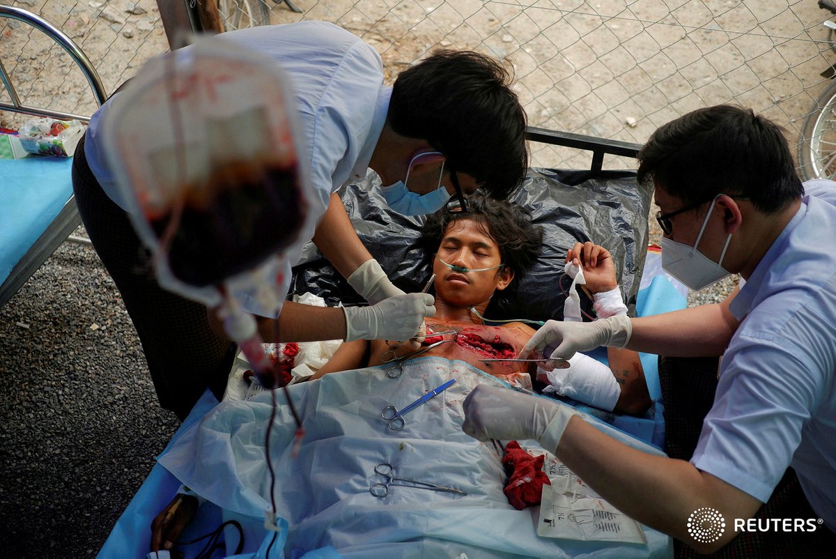 soezeya's tweet photo. Doctors in a makeshift hospital attend a person who was shot during a protest against the military coup in Mandalay, Myanmar March 21, 2021. REUTERS #WhatsHappeningInMyanmar https://t.co/0wIFbX1odh