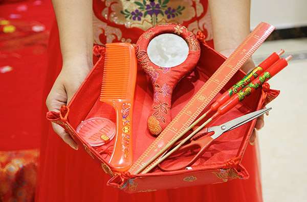 There are whole kits of objects prepared for this ritual! These involve things which symbolise luck (lotus seeds + rulers = abundance of offspring).A pair of red dragon-phoenix candles and joss sticks are lit before starting.