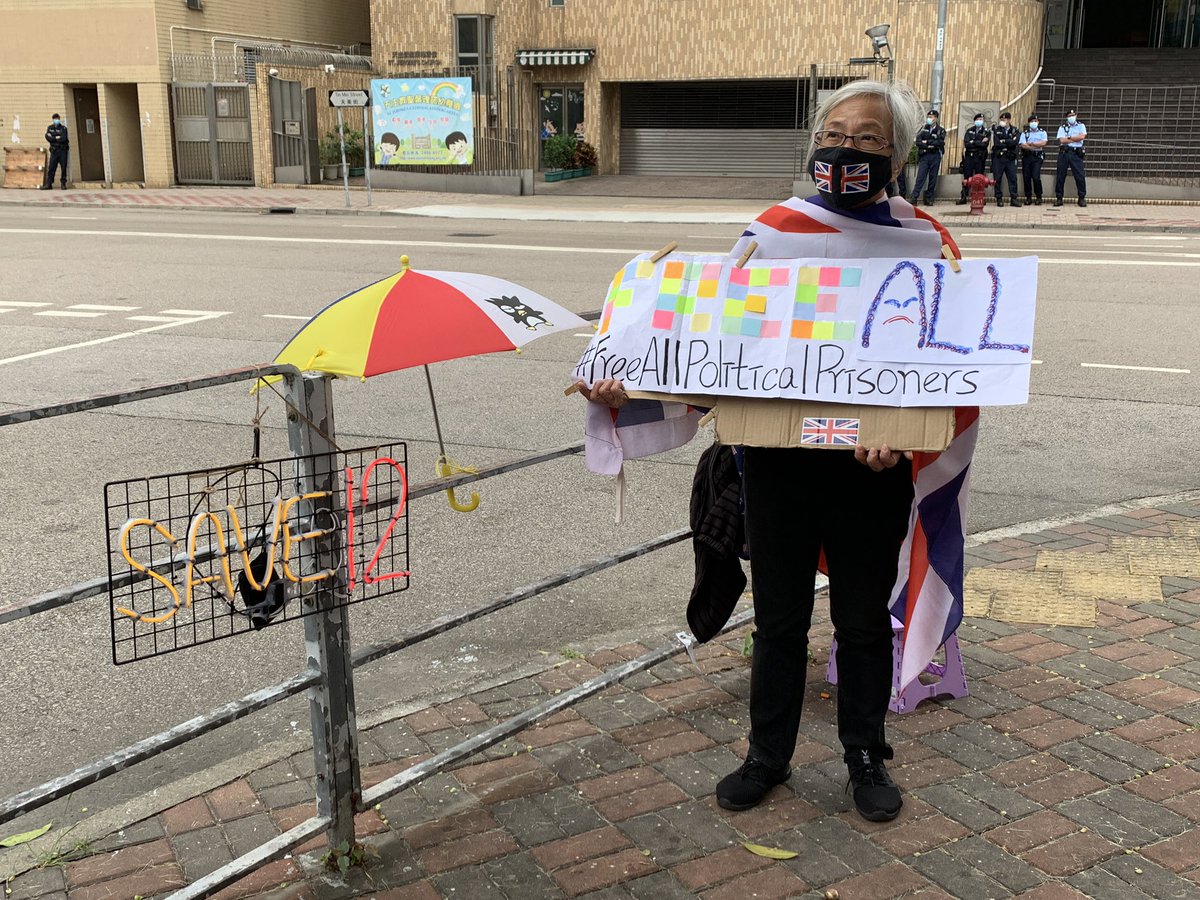 JessiePang0125's tweet photo. 8 of the #12HKYouth are set to be back from Shenzhen to Hong Kong today. Activist Grandma Wong holds a banner reads “Free All Political Prisoners” outside the Tin Shui Wai Police Station as she waits for their return. https://t.co/7MoVhNJnHH