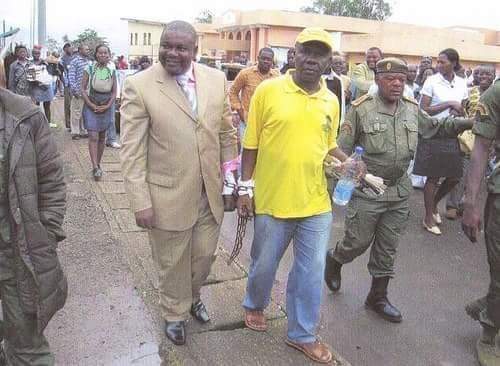 LeBonAsMedia's tweet photo. Photo du JRI Éric Wakam en Août 2008 : à Nkongsamba, le Maire de Njombe-Penja Paul Eric Kingue et l'artiste #Lapiro, inculpés après les "émeutes de la faim", enchaînés l'un à l'autre, quittent, à pieds, le pénitencier pour le Tribunal de Grande Instance du Moungo, pas loin. RIP. https://t.co/vA2Z3lHtbD